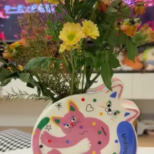 Hugging Cats Vase-A playful ceramic vase featuring two hugging cats covered in colorful doodles